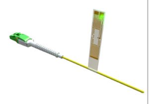 Yellow fiber optic patch cable with green connector and attached label