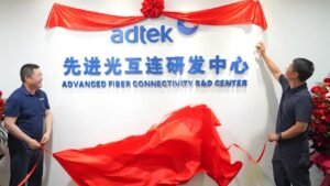 Two men unveiling red ribbon at ADTEK Advanced Fiber Connectivity R&D Center ceremony